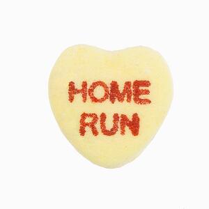 Yellow candy heart that reads home run against white background.