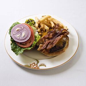 Cheeseburger with bacon and french fries on a plate.