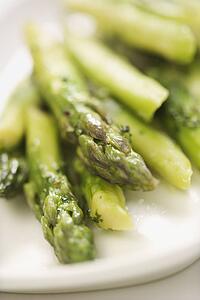 Plate of green cooked asparagus.
