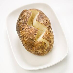 Plain baked potato sliced down the middle on a plate.