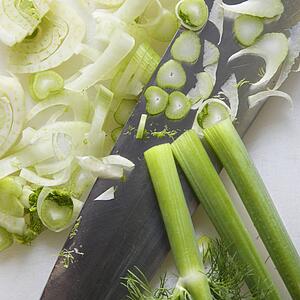 Close up of chopped fennel with large kitchen knife.