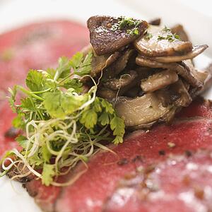 Pepper charred beef carpaccio with mushrooms.