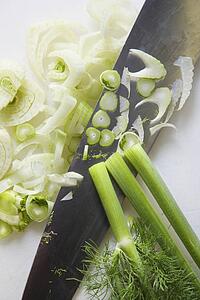 Close up of chopped fennel with large kitchen knife.