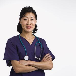 Asian woman doctor half length portrait against white background.