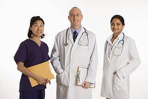 Caucasian mid adult male physician with Asian and Indian women doctors.