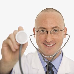 Caucasian mid adult male physician holding up end of stethescope.