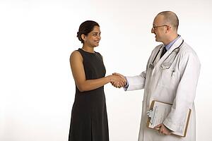Caucasian mid adult male physician talking with Indian woman patient.