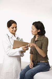Indian woman doctor with Asian woman patient.