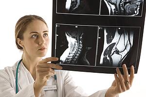 Caucasian mid-adult female doctor analyzing x-ray. 