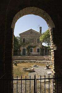 View of Italian dwelling through arched masonry passageway.