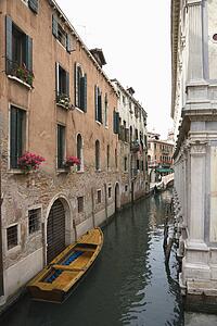 Canal with boat and buildings in Venice, Italy.