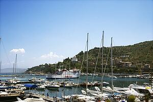 Boats in marina next to coastal villa.