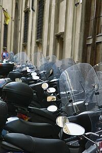 Row of motorcycles beside building, Italy.