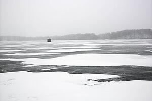 Scenic of frozen lake with ice fishing shack in Green Lake, Minnesota