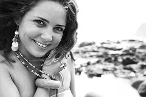 Female smiling holding necklace