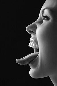 Close up profile of young woman sticking out tongue