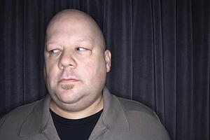 Bald man looking to side.