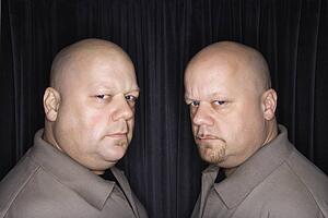 Bald identical twin men looking sternly