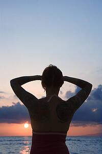 Attractive tattooed woman on beach at sunset 