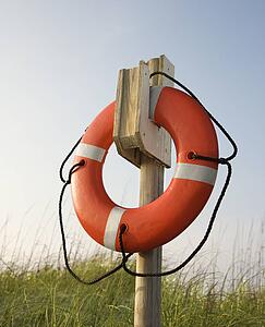 Life preserver hanging on post on beach on Bald Head Island, North Carolina