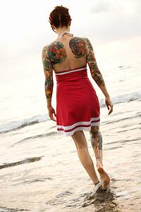 Attractive tattooed Caucasian woman on beach 