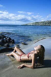 Female lounging in bikini on beach 