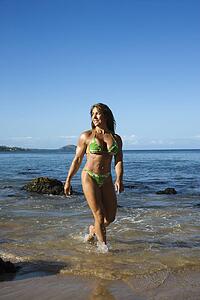 Woman bodybuilder in bikini walking 