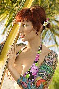 Tattooed woman in bikini on beach 