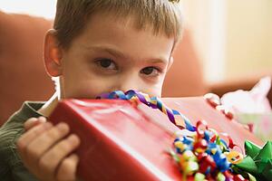 Boy holding gift up to face