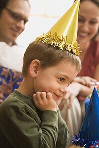 Boy at birthday party looking to the side and smiling