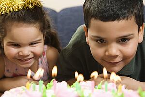 Girl and boy looking at lit candles 