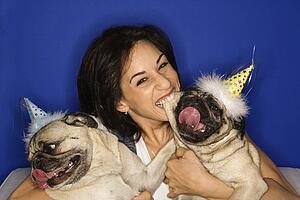 Female holding Pug dogs