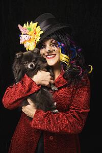 Woman holding black Pomeranian dog