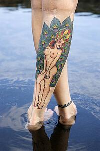 Close up of woman's legs covered with sexy tattoos.