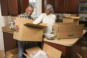 Couple packing moving boxes in kitchen