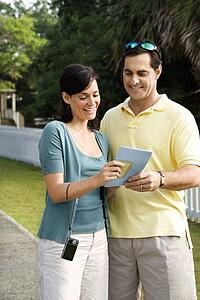 Couple holding map and smiling