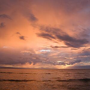Orange glowing clouds during sunset on coast