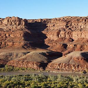 Small river running along rocky desert cliffs in Utah