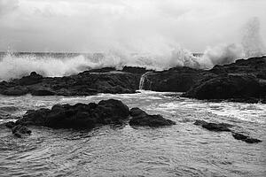 Landscape shot of waves crashing into rocky Hawaii coast.