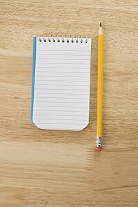 Pencil beside open spiral bound notepad