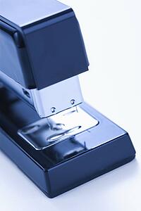 Close up of blue stapler on white background.
