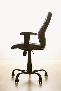 Still life of empty office desk chair.