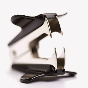 Staple remover on white background with selective focus.