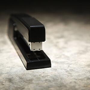 Black stapler on textured background