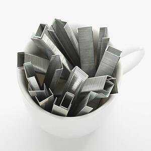 Many staples arranged in a coffee cup.