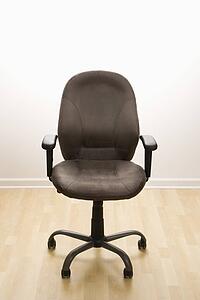 Still life of empty office desk chair.