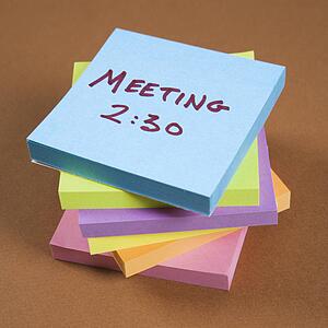 Stack of sticky notes with a meeting reminder.