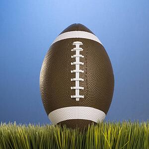 Studio shot of football resting in grass