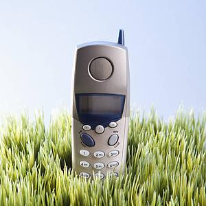 Studio shot of landline telephone placed in grass.
