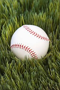 Studio shot of baseball resting in grass